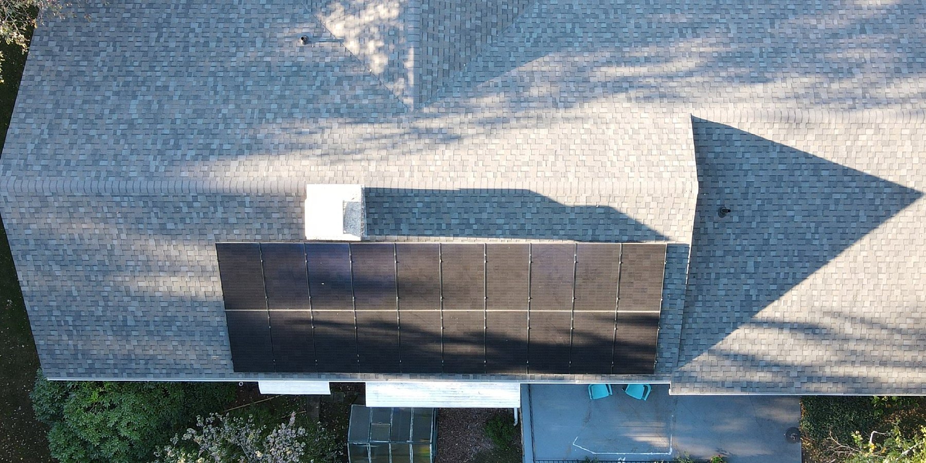 Same roof finished — Williamsburg Gray shingles, solar array reinstalled